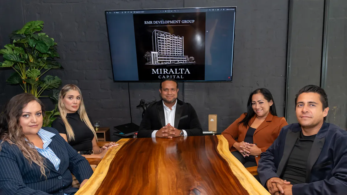 Equipo de RMR Development Group reunido alrededor de una mesa de trabajo